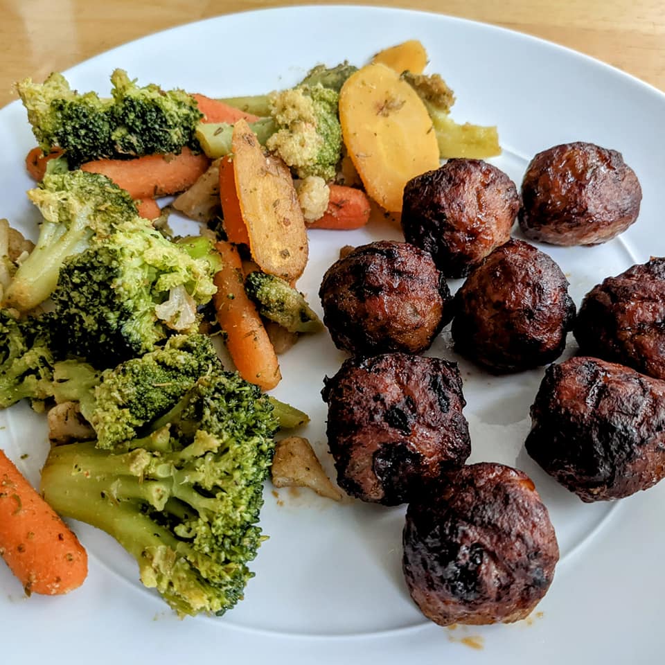 A white plate with mixed vegetables and a pile of Amylu Cranberry Jalapeno Chicken Meatballs from Costco.