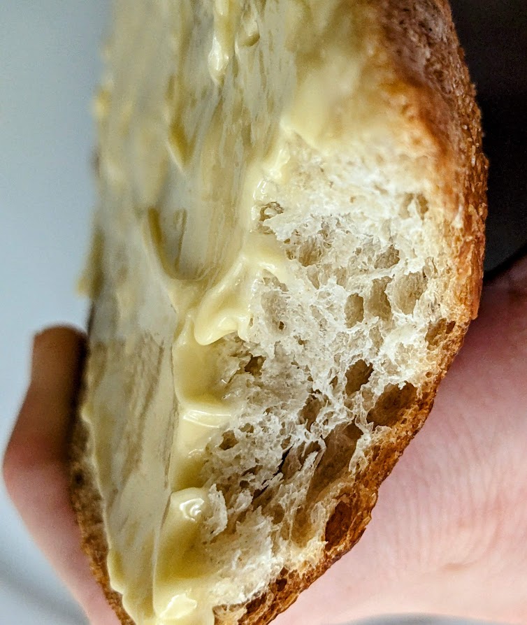 Close up of a buttered and bitten slice of sourdough bread from the Kirkland Costco bakery.