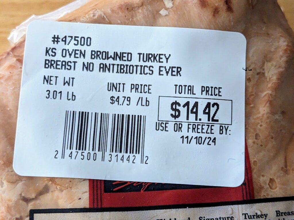 Price sticker with weight and sell-by dates for a Costco Kirkland Oven Browned Turkey Breast.