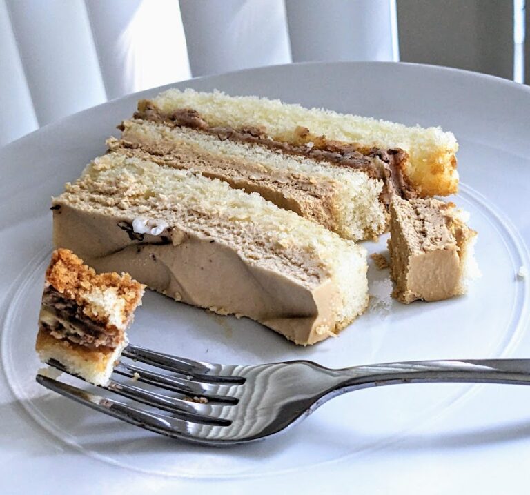 A slice of Maple Butter Pecan Bar Cake from Costco, sitting on a white plate with a fork.