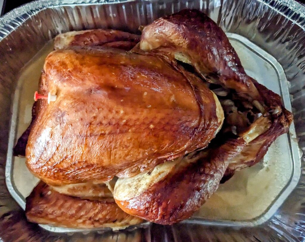 Baked whole Butterball turkey from Publix, with a pop-up timer, in an aluminum roasting pan.