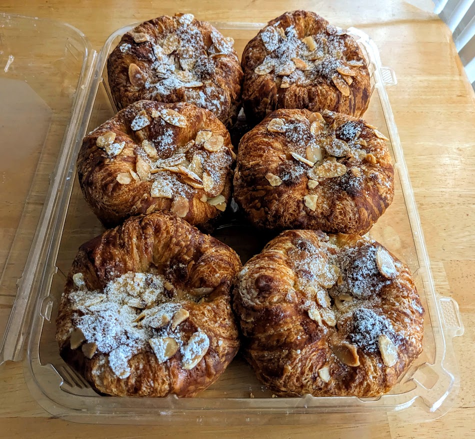 A box of Costco Bakery Almond Croissants sitting on a kitchen table.