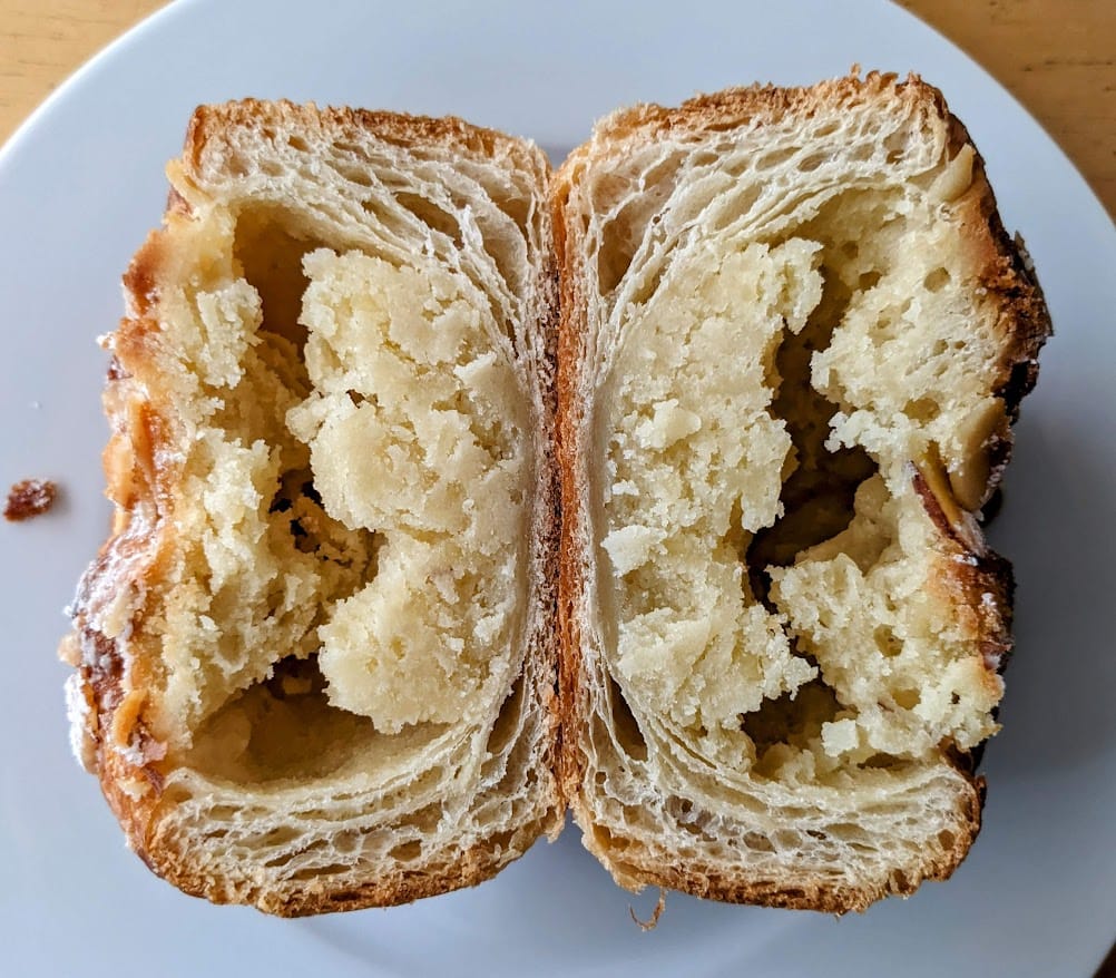 Two halves of a Costco Almond Croissant Pastry, showing the filling inside.