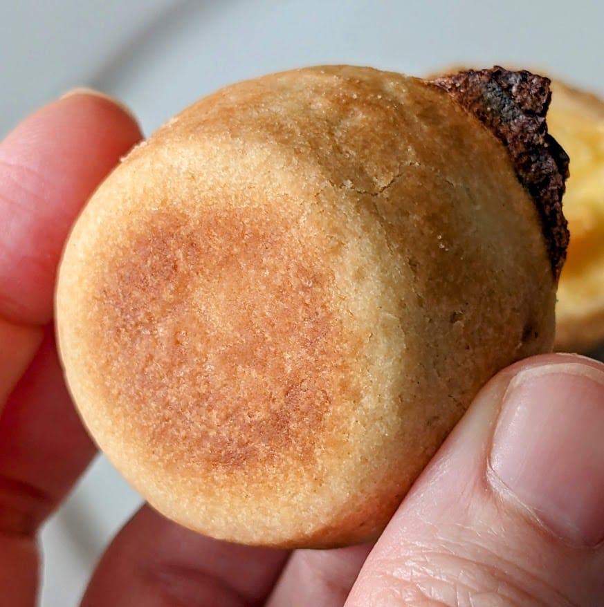 Fingers holding a Cuisine Adventures quiche crust bottom.