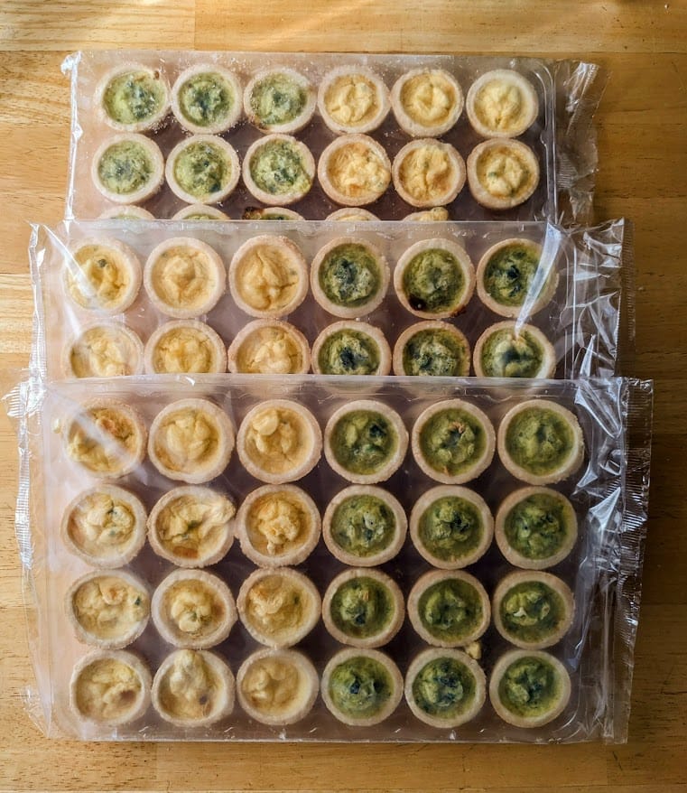 Individually sealed plastic trays of frozen mini quiches from Cuisine Adventures.