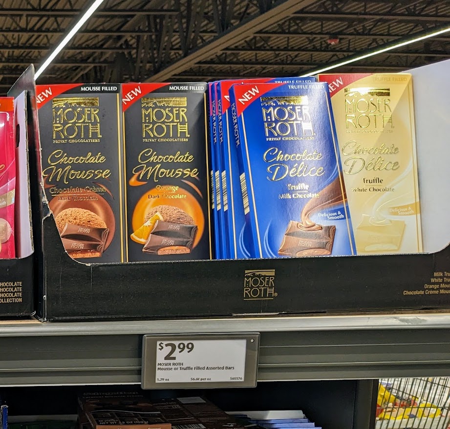 A row of Moser Roth Chocolate Mousse candy bars on a shelf inside an Aldi store.