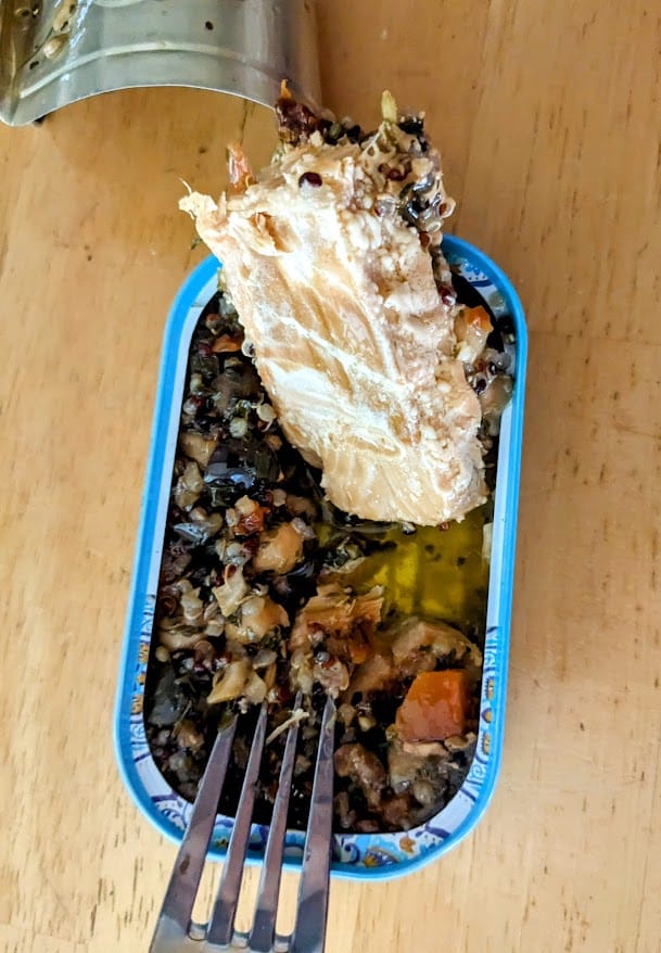 A fork and plank of salmon inside an open can of Freshe Moroccan Tagine.