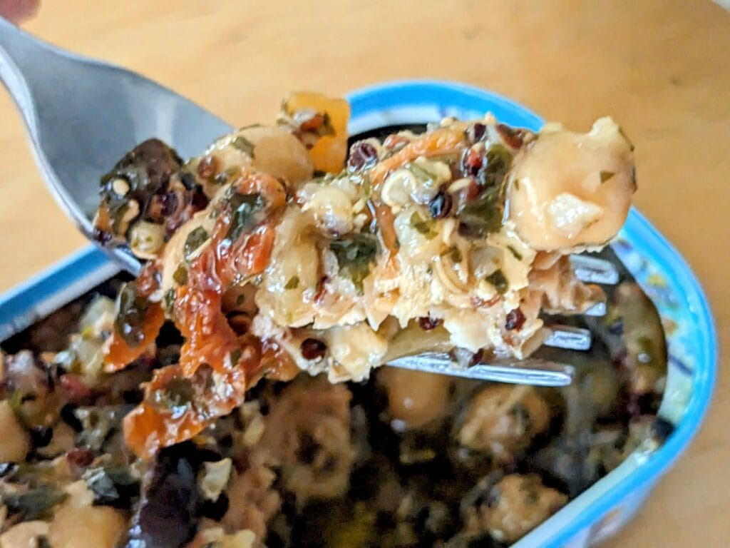 A fork holding a bite of Freshe Gourmet Salmon Meal Moroccan Tagine.