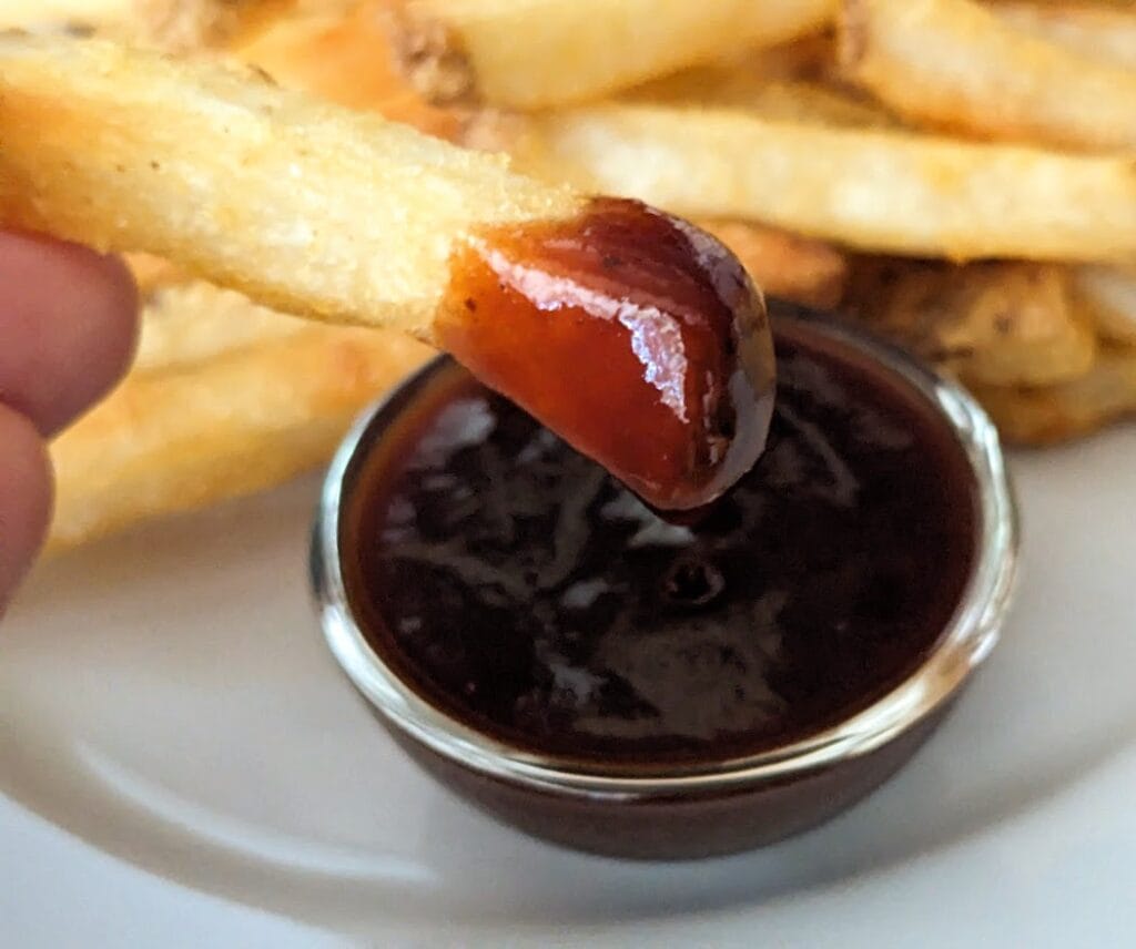 A french fry dipped in Burman's Kansas City Style BBQ Sauce from Aldi.