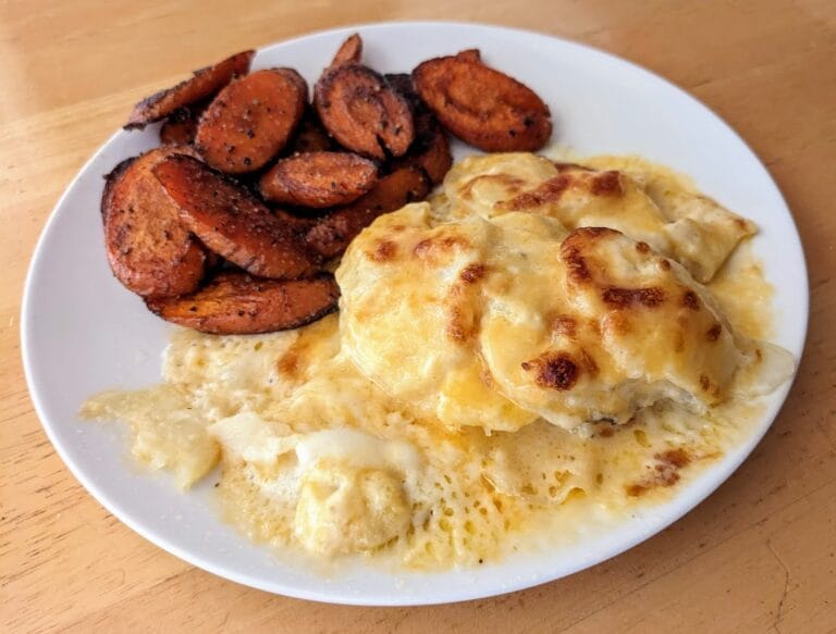 A plate of cheese-covered scalloped potatoes and carrots from Main St Bistro.