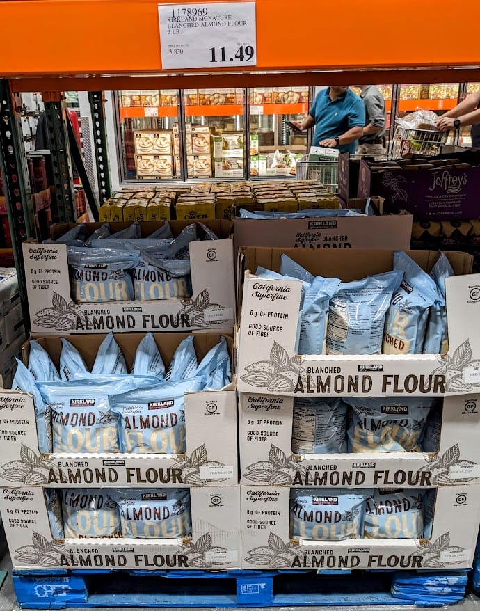 A shelf in a Costco warehouse with a pallet of Kirkland Almond Flour bags.
