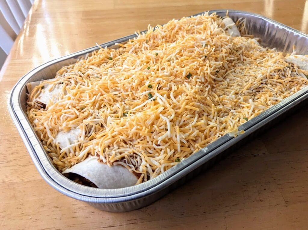 A pan of enchiladas from Sam's Club, sitting on a kitchen table.