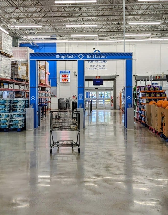 A shopping cart in front of the Exit at a Sam's Club warehouse.