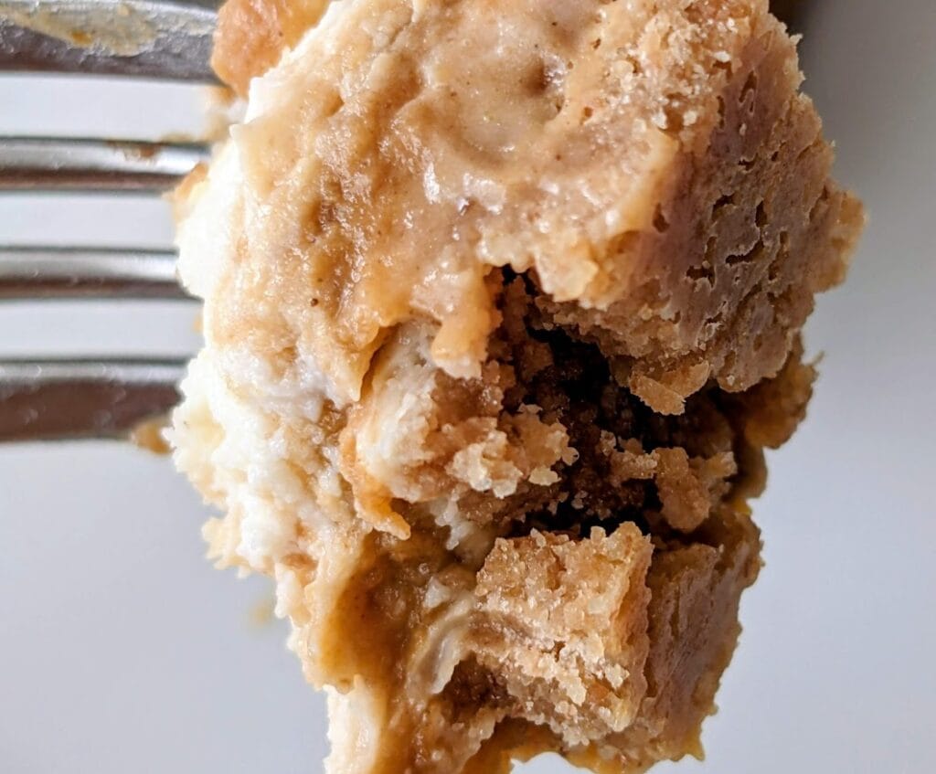 A fork with a bite of Sam's Club Pumpkin Cheesecake, showing the crust texture.