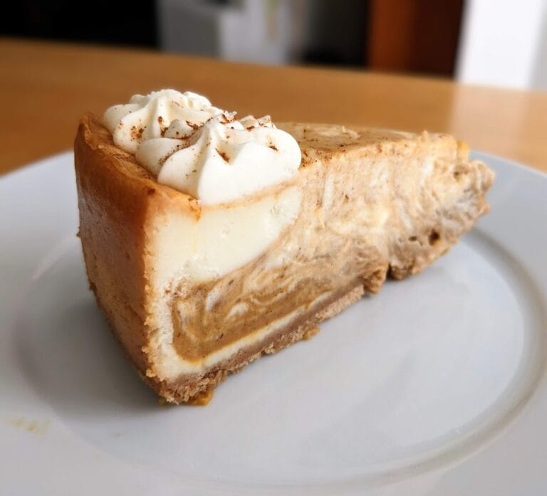 A slice of Member's Mark Pumpkin Cheesecake from Sam's Club, sitting on a white plate.