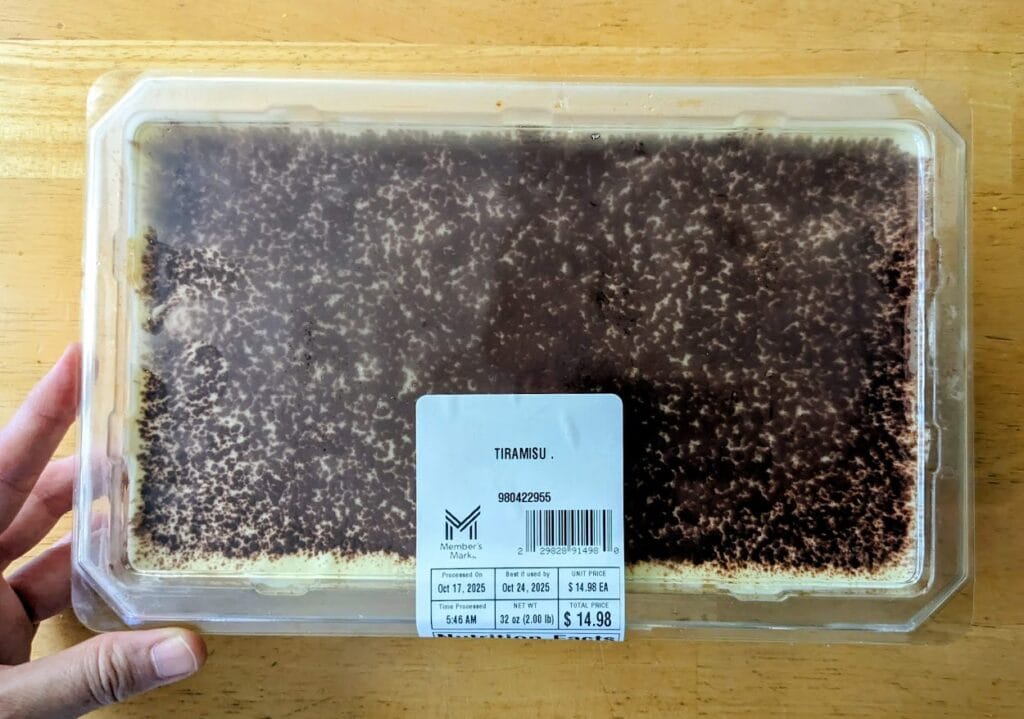 A hand holding a Tiramisu from Sam's Club.