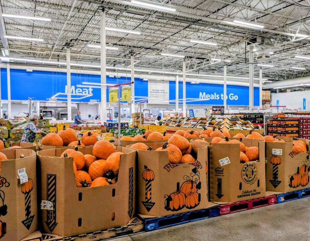Bins of pumpkins inside a Sam's Club warehouse.