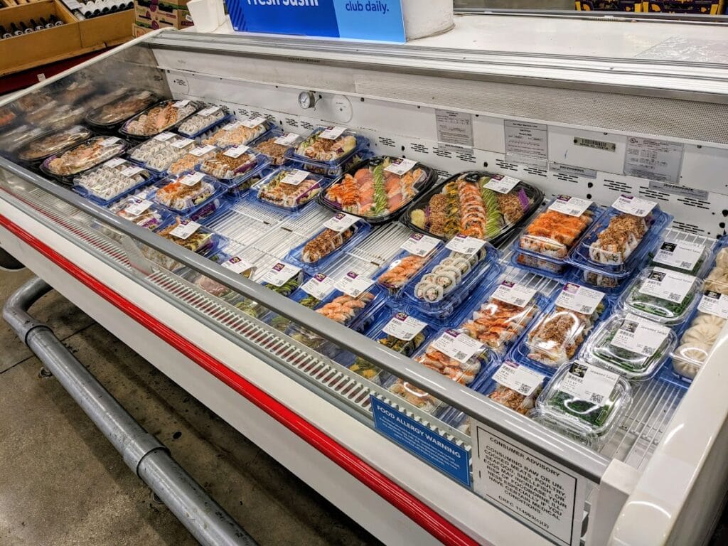 Refrigerated case with trays of sushi inside a Sam's Club.