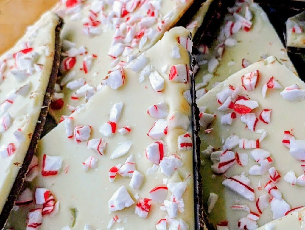 Detail of crushed red and white candy over chocolate on pieces of Costco Kirkland Peppermint Bark.