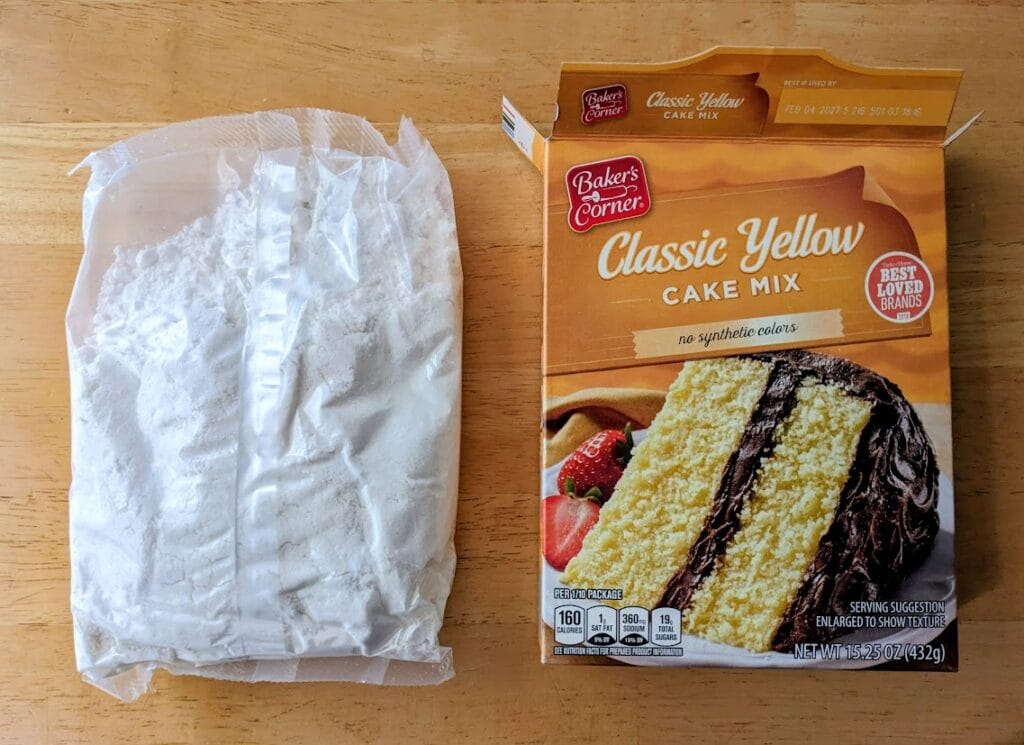 A box of Aldi Baker's Corner Classic Yellow Cake Mix next to a bag of the dry ingredients.