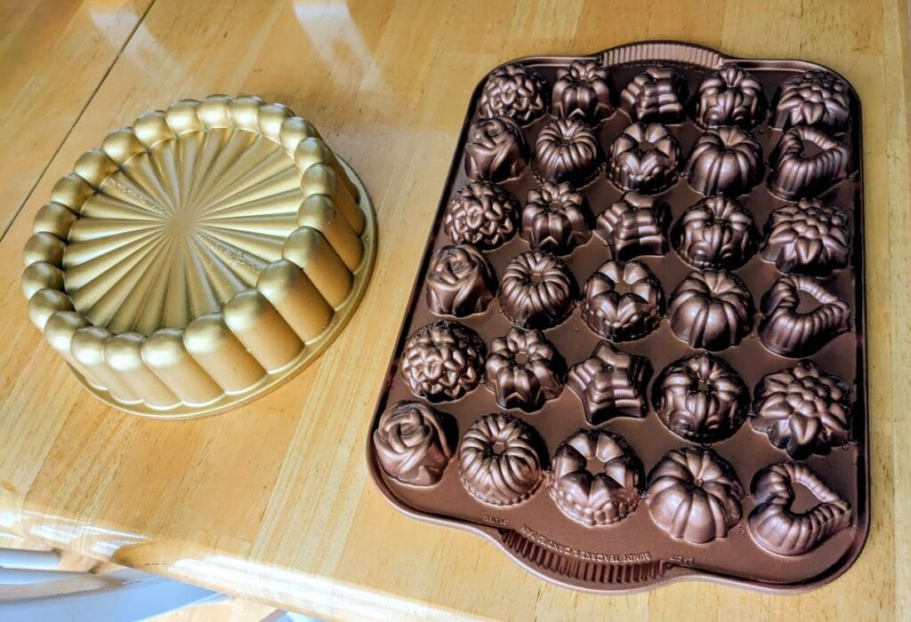 Two shaped Nordic Ware cake pans sitting on a kitchen table.