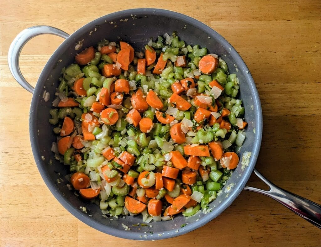 A skillet with sauteed carrots, celery, onions, and garlic.