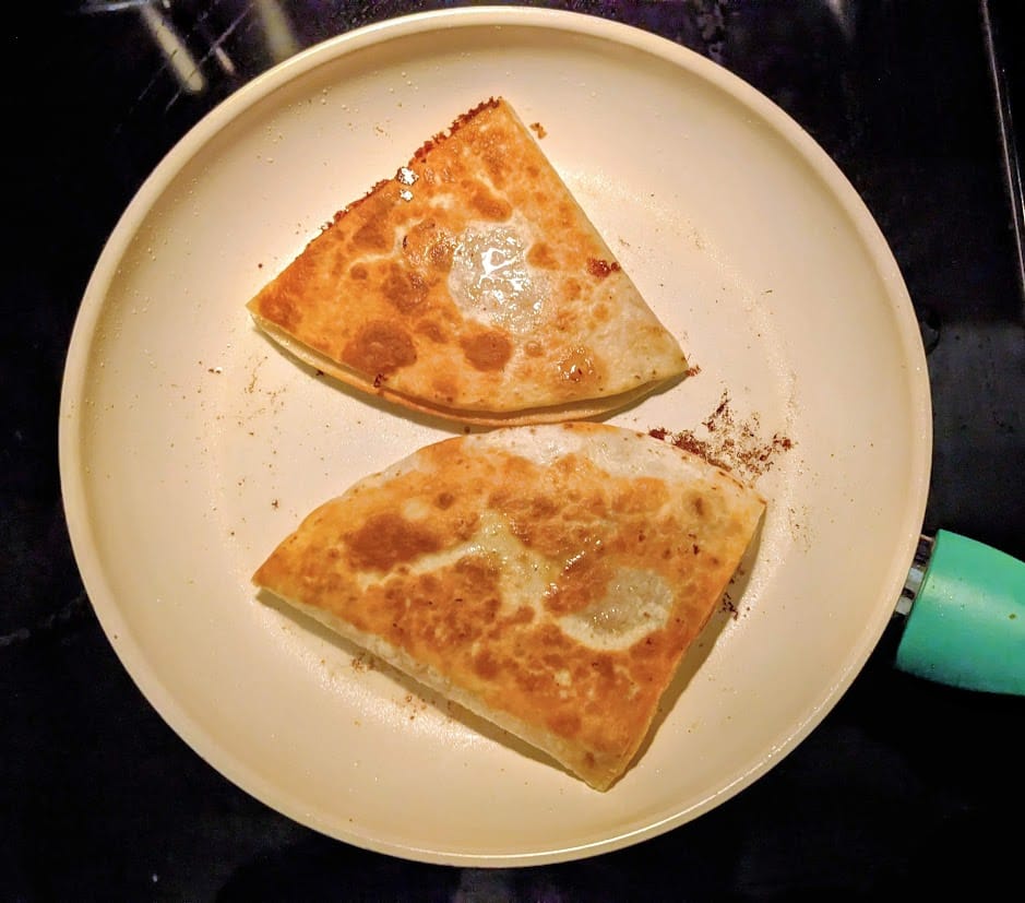 A skillet with two Chicken Quesadillas from Costco.
