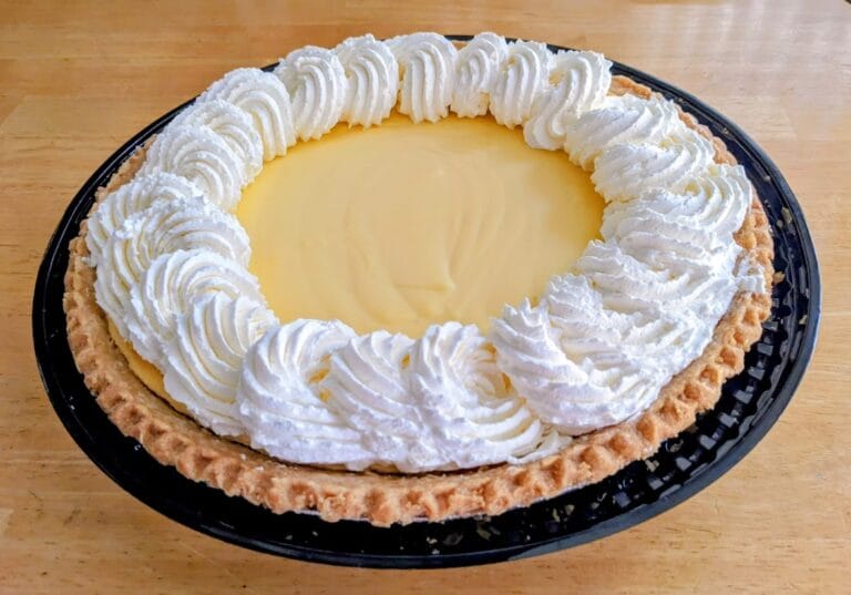 A whole Lemon Custard Pie from Costco, sitting on a kitchen table.