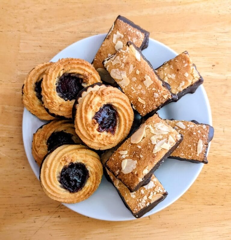 Overhead view of a white plate with two kinds of Aldi Marzipan / Almond Cookies from Specially Selected brand.