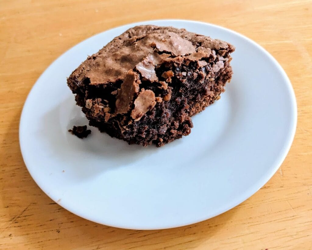 A white plate with a serving of chewy fudge brownie from Aldi.