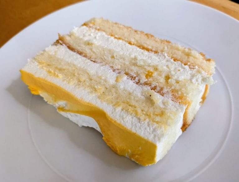A slice of Costco Peaches and Cream Bar Cake with eight layers.