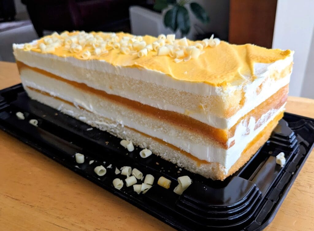 A whole Peaches and Cream Bar Cake from the Costco Bakery sitting on a kitchen table.