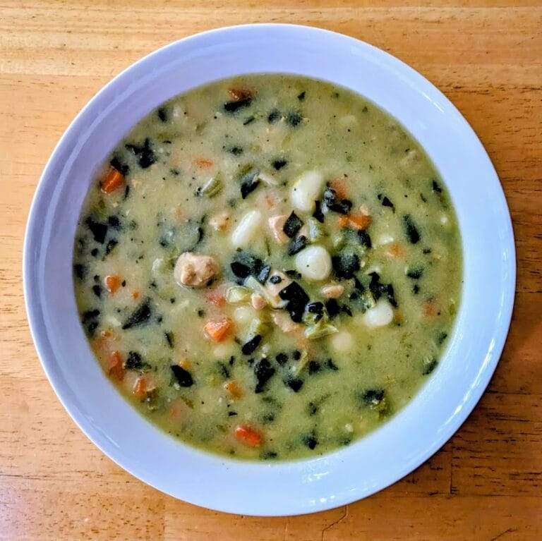 An overhead view of a white bowl of Rao's Chicken & Gnocchi Soup.
