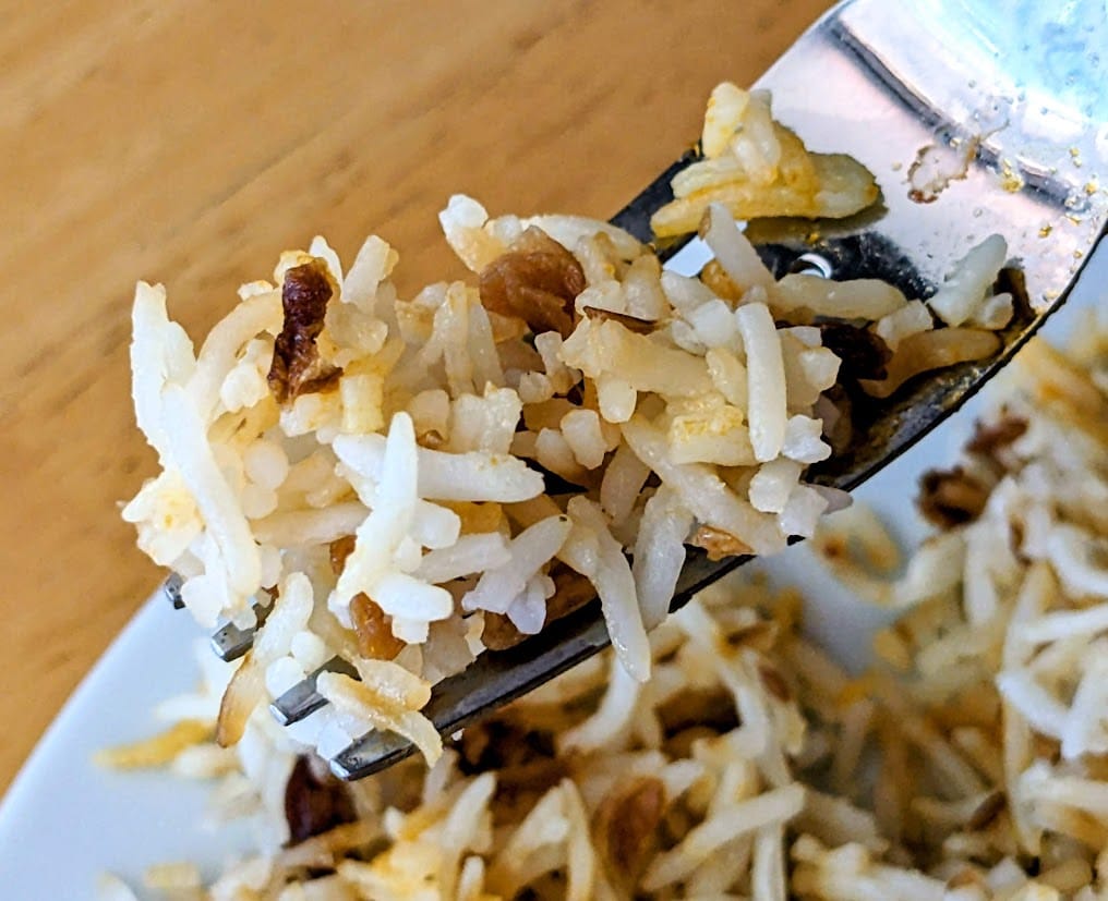 A fork holding a bit of Onion Basmati Rice from a Deep Indian Kitchen meal.