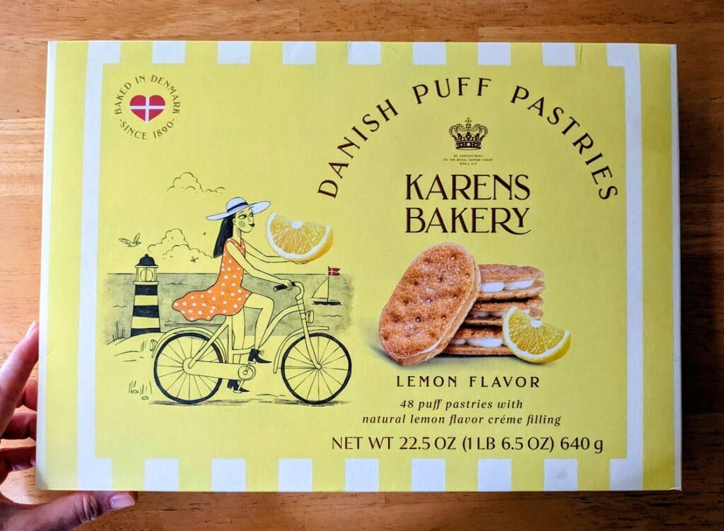 A hand holding a box of Karens Bakery Danish Puff Pastries Lemon Flavor Cookies from Costco.