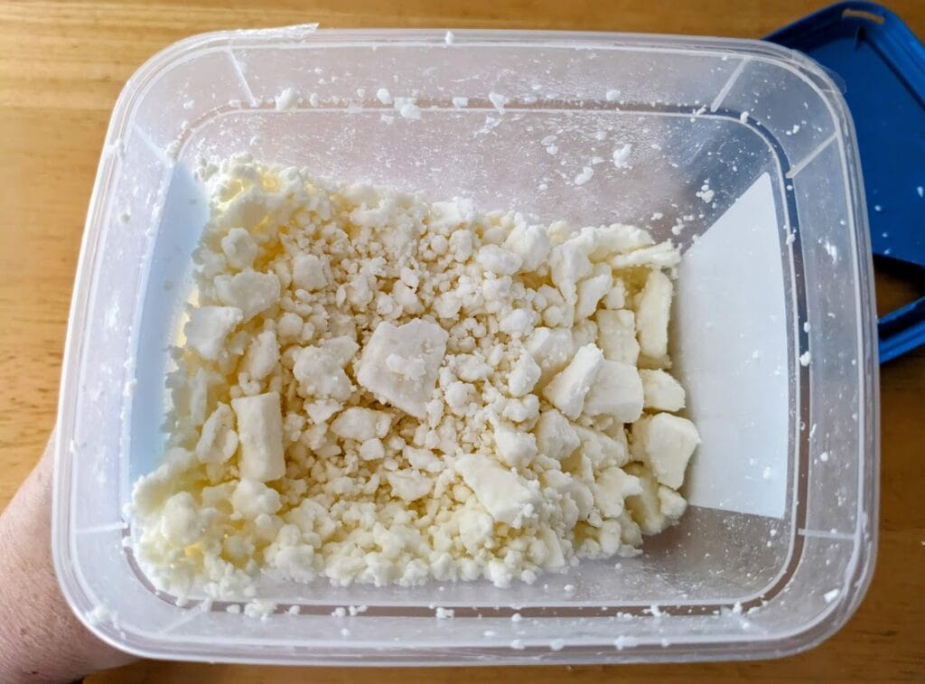 An open plastic tub of President Crumbled Feta from Costco.