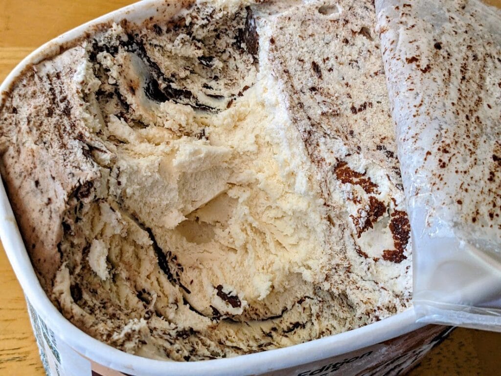 An open carton of Publix brand Buckeyes & Fudge Ice Cream, with a scoop removed.