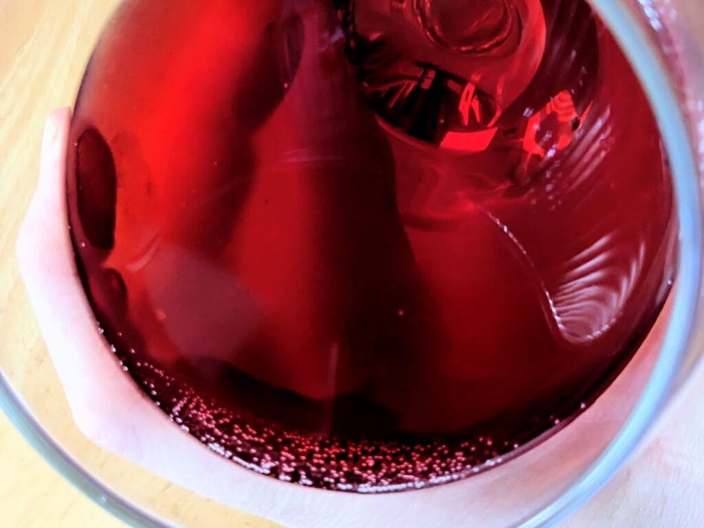 Close up of red juice texture in Sprouts Organic Pomegrate Italian Soda.