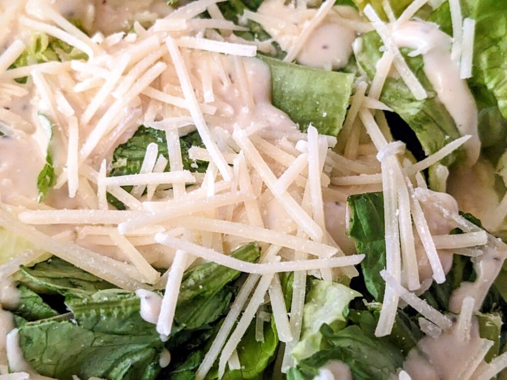 Parmesan cheese shreds on top of a Taylor Farms Caesar Salad.