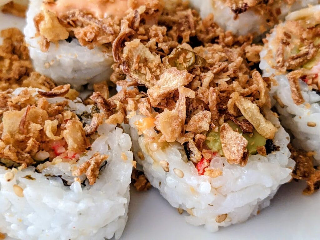 Crunchy fried onions on top of California sushi rolls from Costco.
