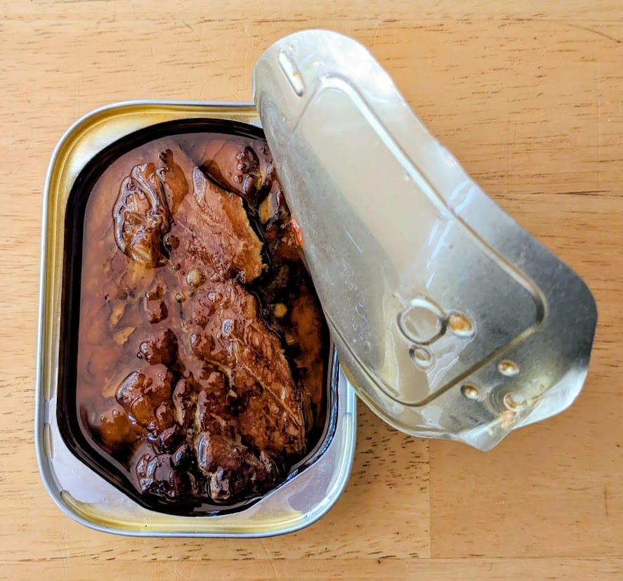 An open can of Fishwife Smoked Mackerel with Chili Flakes packed in olive oil.