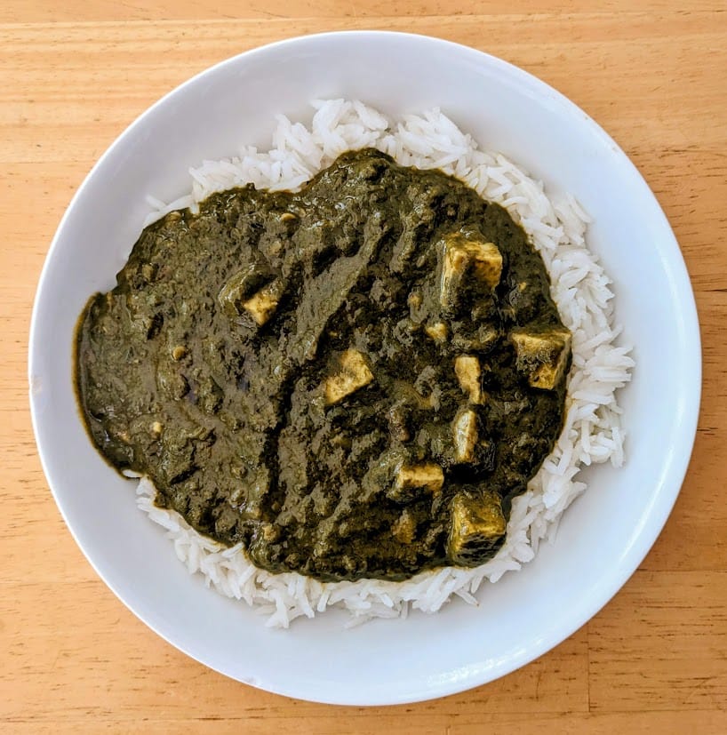 A bowl of basmati rice covered in palak paneer from MTR Minute Meals.