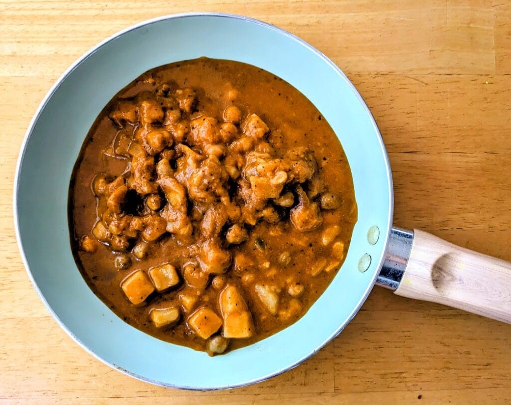 A ceramic skillet with Maya Kaimal Organic Madras Potato Curry.
