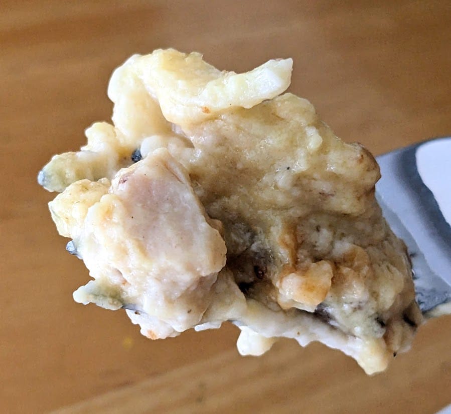 A fork holding a bite of Rana 4 Cheese Chicken Carbonara Lasagna from Costco.