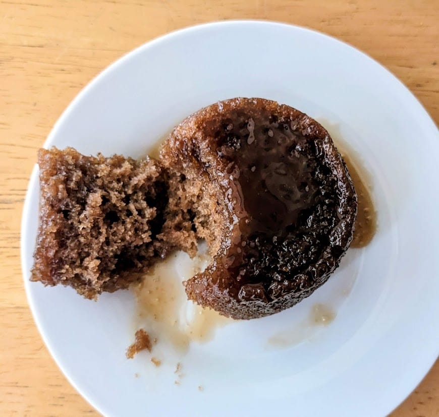 A white plate with an overhead view of The Sticky Toffee Pudding Co. British single serve dessert from Costco.