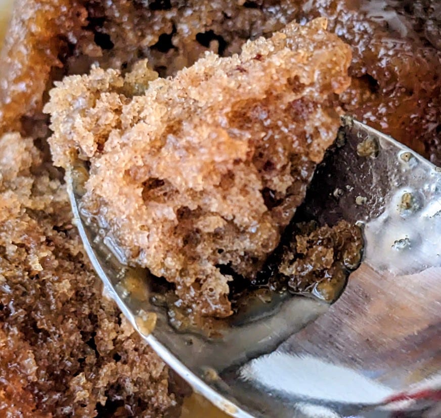 A spoon holding a bite of British Sticky Toffee Pudding Co. dessert from Costco.