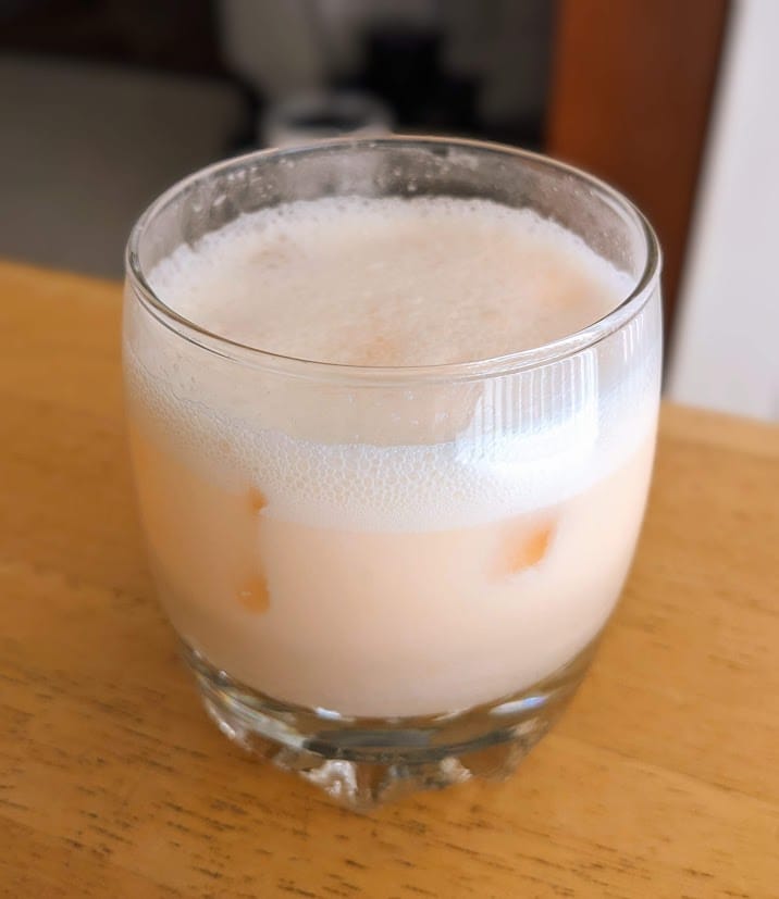 A glass of cream soda made with Welch's Sparkling Passion Fruit Mango drink.