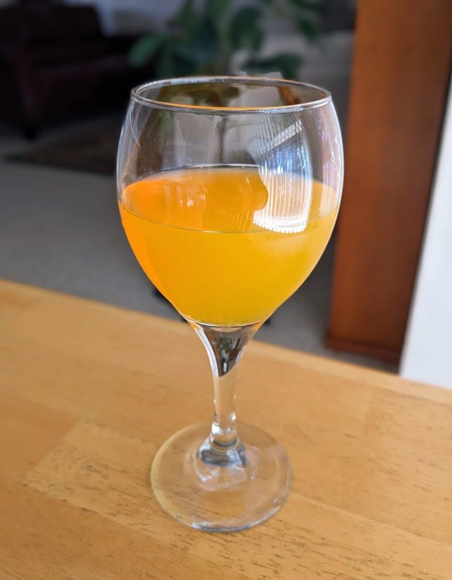 A wine goblet with Welch's Passion Fruit Mango sparkling beverage.