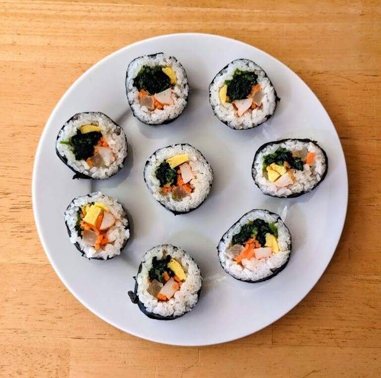 A white plate with 8 pieces of Aldi Traditional Korean Kimbap.