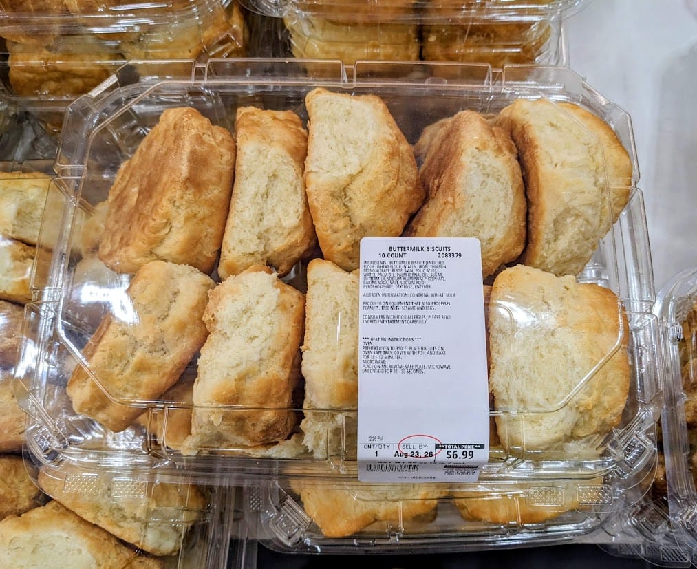 A plastic box of Buttermilk Biscuits inside a Costco warehouse.